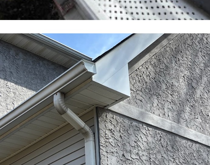 White downspout installed against light siding