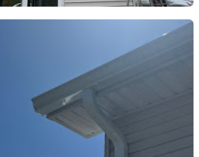New seamless white aluminum gutter against a clear blue sky