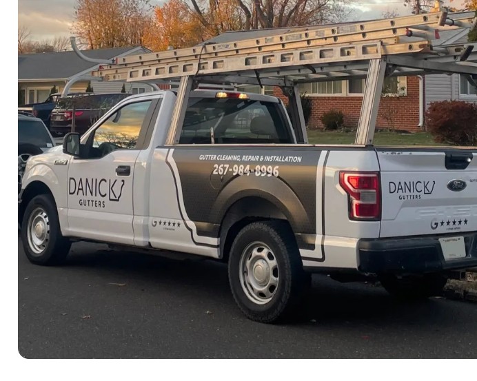 Danick Gutters truck with ladder rack at a job site